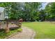 Backyard showing a lush lawn, mature trees, outdoor seating, and a wooden deck at 380 Russell Rd, Lawrenceville, GA 30043