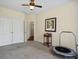 A well-lit carpeted bedroom with a ceiling fan, double doors, and a small indoor trampoline at 380 Russell Rd, Lawrenceville, GA 30043
