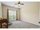 A carpeted bedroom is brightly lit by a large window with a ceiling fan at 380 Russell Rd, Lawrenceville, GA 30043