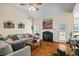 Open-concept living room featuring a fireplace, vaulted ceiling, hardwood floors, and an abundance of natural light at 380 Russell Rd, Lawrenceville, GA 30043
