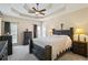 Bedroom with a tray ceiling, ceiling fan, neutral color palette, and access to the backyard at 380 Russell Rd, Lawrenceville, GA 30043