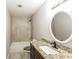 Bathroom features a granite countertop, tile flooring, shower, and a round mirror at 6480 Port A Prince Drive Dr, Forest Park, GA 30297