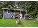 Charming two-story home with gray siding, white trim, lawn and unique wishing well at 6480 Port A Prince Drive Dr, Forest Park, GA 30297