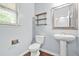 Bathroom with toilet, sink, mirror, shelves and window at 2166 Villa Spring Ct, Dacula, GA 30019