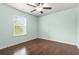 Bedroom featuring wood floors, a ceiling fan, and a window with outdoor views at 2166 Villa Spring Ct, Dacula, GA 30019
