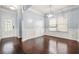 Formal dining room featuring hardwood floors, wainscoting, elegant lighting, and a large window at 2166 Villa Spring Ct, Dacula, GA 30019