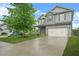 Two-story home with a two-car garage, covered porch, and mature trees in the front yard at 2166 Villa Spring Ct, Dacula, GA 30019