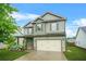 Two-story home with a two-car garage, welcoming covered porch, and manicured lawn at 2166 Villa Spring Ct, Dacula, GA 30019
