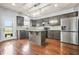 Modern kitchen with stainless steel appliances, center island, and stylish cabinetry and hardwood floors at 2166 Villa Spring Ct, Dacula, GA 30019