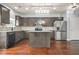 A modern kitchen features stainless steel appliances, gray cabinets, a center island and hard wood floors at 2166 Villa Spring Ct, Dacula, GA 30019