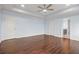 A spacious main bedroom with hardwood floors, a tray ceiling, ceiling fan and two doors at 2166 Villa Spring Ct, Dacula, GA 30019