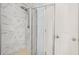 Frameless glass shower with white marble tile, multiple shower heads, and white hexagon tile floor at 2166 Villa Spring Ct, Dacula, GA 30019