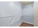 Walk-in closet complete with white wire shelving, dark hardwood floors and light grey walls at 2166 Villa Spring Ct, Dacula, GA 30019