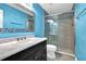 Bathroom with a gray tiled shower, marble countertop, and bright blue walls at 7027 Walham Grv, Duluth, GA 30097