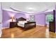 A large bedroom with hardwood floors, tray ceiling, and decorative trim at 7027 Walham Grv, Duluth, GA 30097