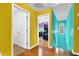 Hallway leading to bedroom with hardwood floors and yellow and blue accent walls at 7027 Walham Grv, Duluth, GA 30097
