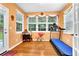 A well-lit sunroom features a treadmill and a decorative display table with multiple windows at 7027 Walham Grv, Duluth, GA 30097