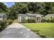 Home exterior featuring a long driveway and a lush green lawn with mature landscaping at 1385 Kenilworth Sw Dr, Atlanta, GA 30310