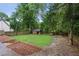 Landscaped backyard with a rustic shed and defined planting beds at 27 Sessions Nw St, Marietta, GA 30060