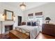 Charming bedroom featuring a decorative fireplace, a bed with blue throw pillows, and wood paneled walls at 27 Sessions Nw St, Marietta, GA 30060