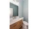Stylish bathroom with wood vanity, modern fixtures, a toilet, and decorative mirror at 3286 Bachelor Street, East Point, GA 30344
