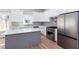Well-lit kitchen with stainless steel appliances, white cabinets, quartz countertops, and island at 3286 Bachelor Street, East Point, GA 30344