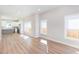 Open-concept living room with hardwood floors and view of kitchen with white cabinets and quartz countertops at 3286 Bachelor Street, East Point, GA 30344