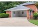 Three-car carport with long driveway, brick exterior, white trim, and storage area at 3589 Stone Ridge Trl, Douglasville, GA 30134