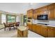 Kitchen with light wood cabinets, black cooktop, microwave and eat-in area with view to back yard at 3589 Stone Ridge Trl, Douglasville, GA 30134