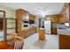 Traditional kitchen with oak cabinets, white appliances, floral wallpaper, and a rolling island at 3589 Stone Ridge Trl, Douglasville, GA 30134