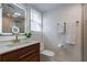 Modern bathroom features gold fixtures, a glass shower, and a lighted mirror above the wooden vanity at 4282 Roswell Ne Rd # G1, Atlanta, GA 30342
