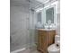 Modern bathroom features a glass shower, marble tile, and lighted mirror above the wood vanity at 4282 Roswell Ne Rd # G1, Atlanta, GA 30342