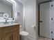 Bright bathroom with a wooden vanity cabinet, marble countertop, lighted mirror, and white door at 4282 Roswell Ne Rd # G1, Atlanta, GA 30342