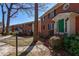 Charming red brick apartment building with black shutters, green door, and mature trees at 4282 Roswell Ne Rd # G1, Atlanta, GA 30342
