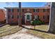 Traditional brick apartment building with a well-manicured lawn and a green front door at 4282 Roswell Ne Rd # G1, Atlanta, GA 30342