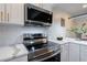 The renovated kitchen features stainless steel appliances, white cabinetry, and marble countertops at 4282 Roswell Ne Rd # G1, Atlanta, GA 30342