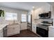 Well-lit modern kitchen boasts stainless steel appliances, white subway tile backsplash, and white cabinets with gold hardware at 4282 Roswell Ne Rd # G1, Atlanta, GA 30342
