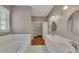 Large bathroom featuring double sinks, soaking tub, and access to a walk-in closet at 4815 Rapids Nw Cir, Acworth, GA 30102