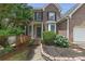Front entrance of brick home featuring a covered entryway and manicured shrubs at 4815 Rapids Nw Cir, Acworth, GA 30102