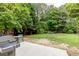 Spacious backyard, surrounded by mature trees and landscaping, with patio, grill and soccer net at 1921 Northbrooke Ln, Dunwoody, GA 30338