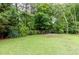 Expansive backyard featuring lush greenery, mature trees, and a fenced perimeter, perfect for outdoor activities at 1921 Northbrooke Ln, Dunwoody, GA 30338