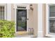 A welcoming front door with sidelight, glass door, and decorative shrubbery at 1921 Northbrooke Ln, Dunwoody, GA 30338