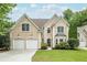 Charming home with a well-manicured lawn, two-car garage, and neutral stucco facade at 1921 Northbrooke Ln, Dunwoody, GA 30338