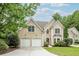 Charming two-story home with a well-manicured lawn, two-car garage, and neutral stucco facade at 1921 Northbrooke Ln, Dunwoody, GA 30338