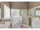 Bright bathroom with double sinks, a glass block window, and a separate shower and tub at 1921 Northbrooke Ln, Dunwoody, GA 30338