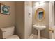 Elegant powder room with pedestal sink, oval mirror, and decorative wall accents at 1921 Northbrooke Ln, Dunwoody, GA 30338