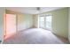 Bright bedroom with plush carpet, ceiling fan, and double windows overlooking the yard at 2214 Lake Pointe Cir, Roswell, GA 30075