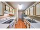 Galley kitchen featuring white appliances, white countertops, and ample cabinet space at 2214 Lake Pointe Cir, Roswell, GA 30075