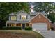 Charming two-story home featuring a brick facade, a covered porch and a manicured lawn at 2711 Brookefield Nw Ln, Kennesaw, GA 30152
