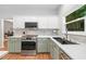 Bright kitchen features white cabinets, stainless steel appliances, a gas range and solid surface countertops at 2711 Brookefield Nw Ln, Kennesaw, GA 30152